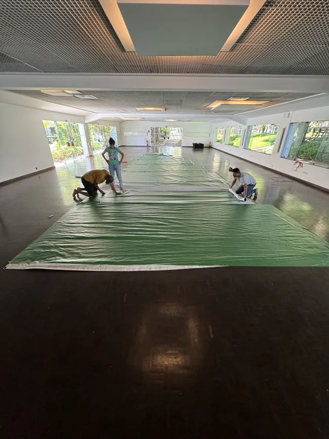 Equipe trabalhando sobre a vela durante a aplicação da identidade visual Heineken.