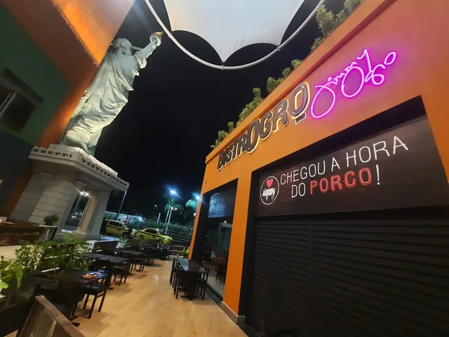 Letreiro iluminado do Bistrô OGGRO aplicado à fachada durante a noite.