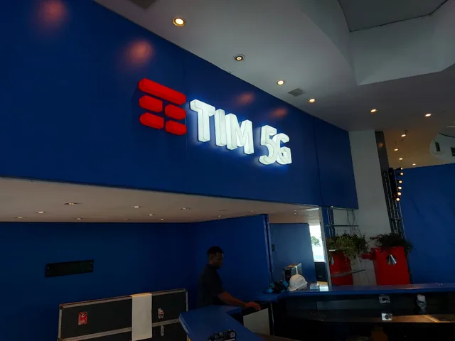 Letreiro iluminado TIM 5G na entrada da loja.